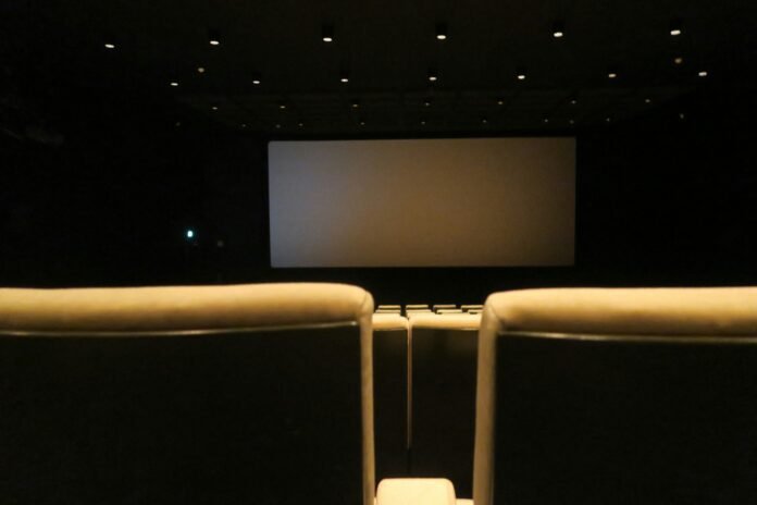 Sala de cine con butacas rojas vacías frente a la pantalla, representa los cines en Saltillo Coahuila