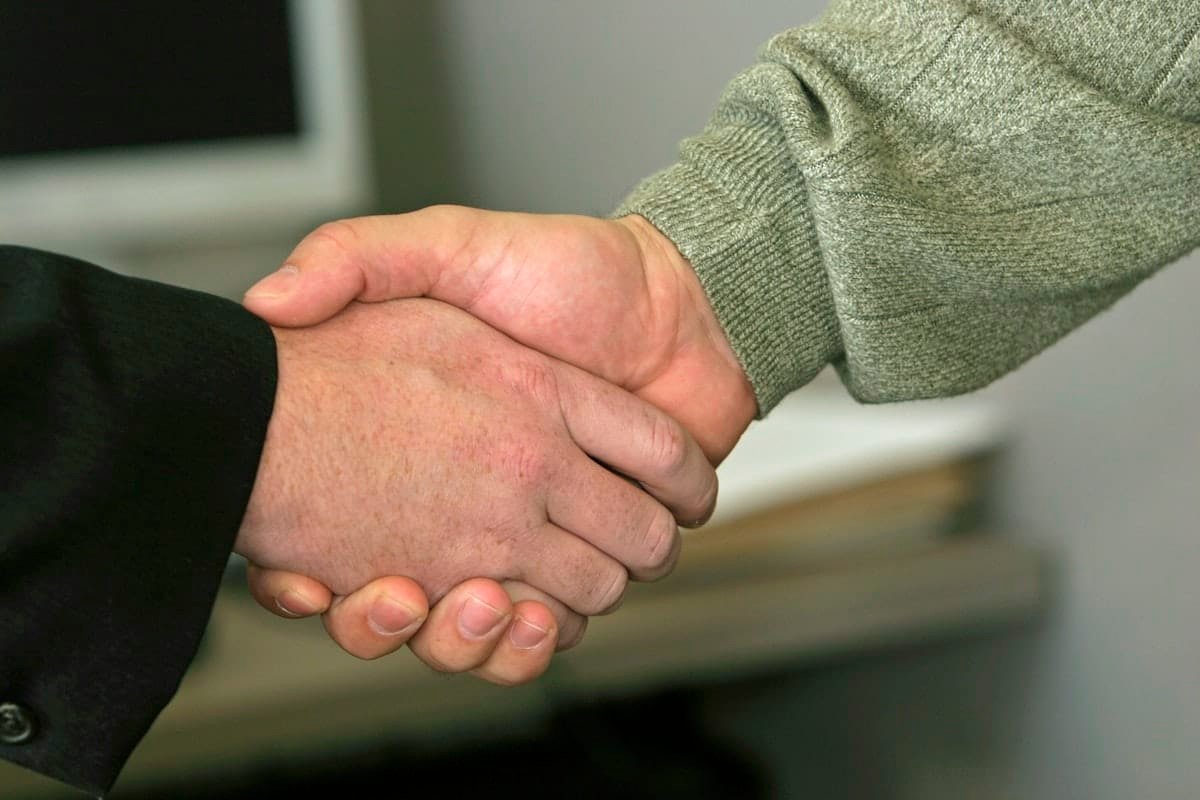 Dos personas dándose la mano como saludo